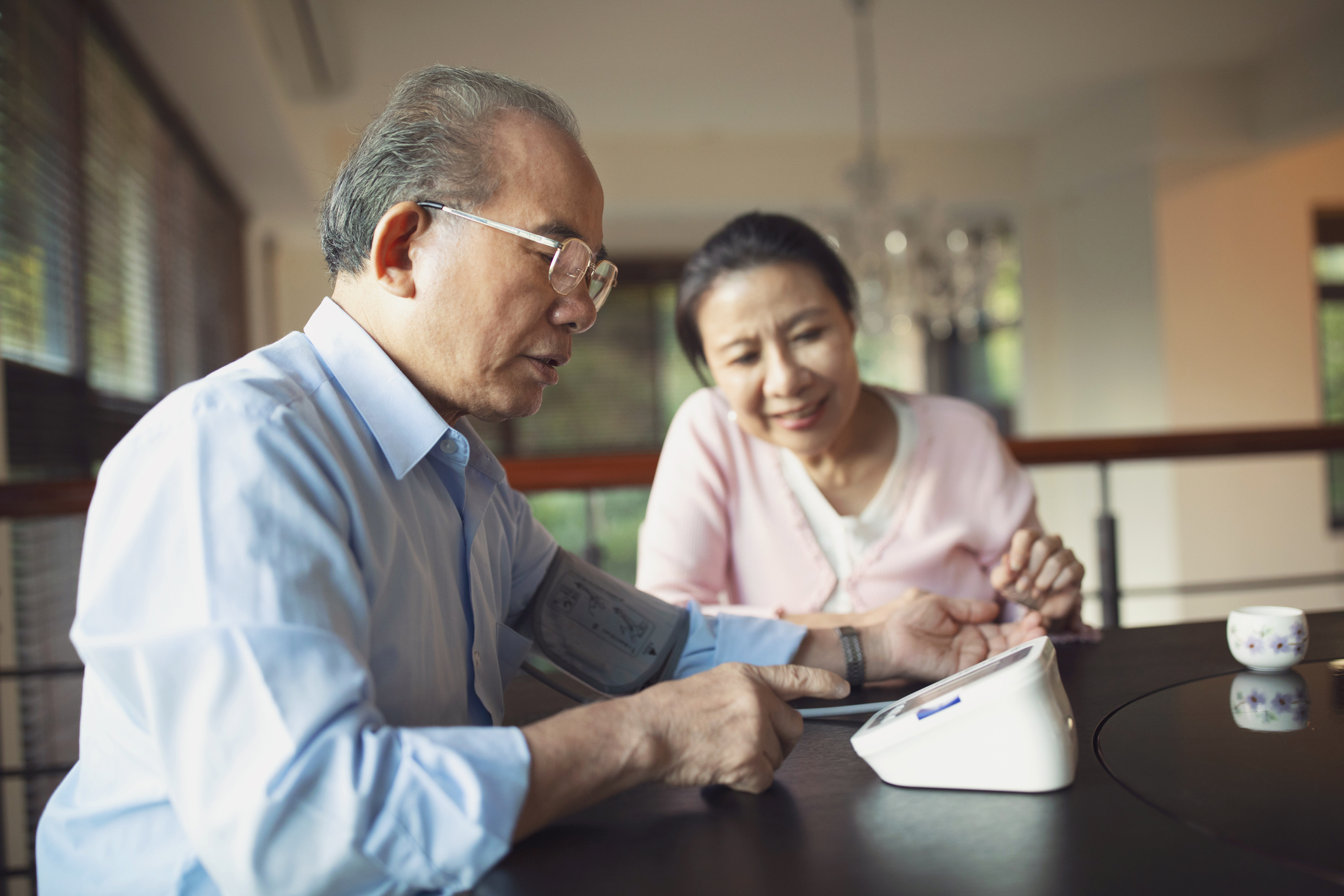 Senior man monitoring his blood pressure at home