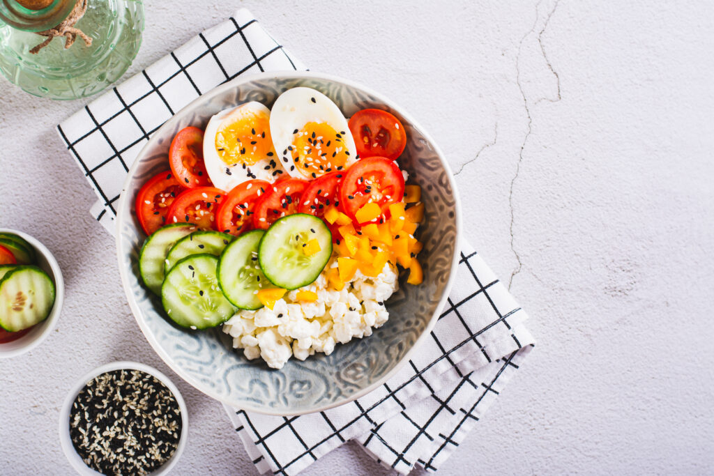 Cottage cheese, hard boiled egg and vegetables in a bowl
