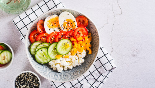 Cottage cheese, hard boiled egg and vegetables in a bowl