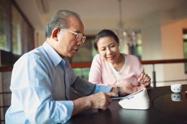 Senior man monitoring his blood pressure at home